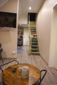 a living room with a wooden table and a staircase at Wohnung Burghaus 5 OG in Krummhörn