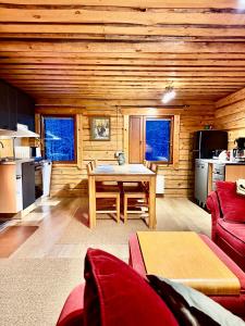 a living room with a table and a kitchen at Authentic Log Cottage with Hot Tub in Ranua