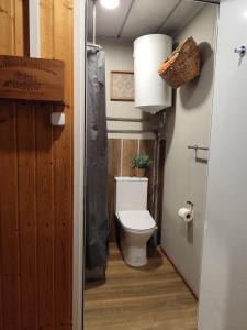 a bathroom with a toilet with a plant in it at Natura Tiny House Porto in Valongo