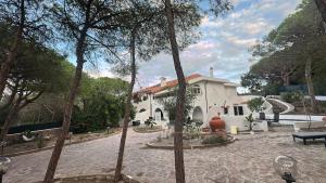 a white house with a stone courtyard with a staircase at Villa La Caletta in Carloforte