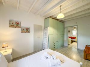a bedroom with a white bed with towels on it at Stone Haven & Garden near the Sea in Methoni