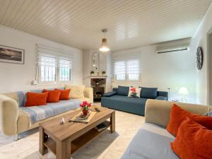 a living room with two couches and a table at Stone Haven & Garden near the Sea in Methoni