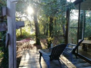 a patio with two chairs and a table on a deck at Natura Tiny House Porto in Valongo