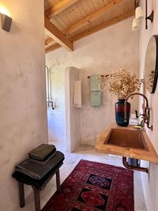 ein Badezimmer mit Waschbecken und einer Blumenvase in der Unterkunft Casa 5A - Refúgio Intimo e privado com design e pátio acolhedor in Oliveira do Mondego