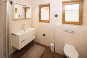 a white bathroom with a sink and a toilet at Appartement Moaeben - Panorama in Alpbach