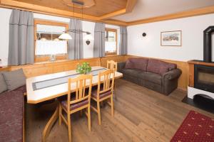 a living room with a table and chairs and a couch at Appartement Moaeben - Panorama in Alpbach +32 photos