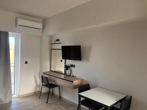 a room with a desk and a table and a television at Barbie II in Ialysos