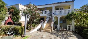 a white house with a staircase in front of it at Apartments Bresina in Povljana