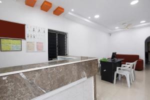 an office with a counter and a desk and chairs at Via Neverland Residency in Pedappai +28 photos