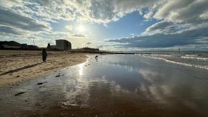 a person walking on the beach near the water at Flat 4A in Edinburgh +5 photos