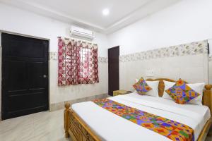 a bedroom with a bed and a black door at Via Neverland Residency in Pedappai