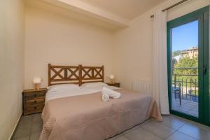a bedroom with a bed and a large window at Apartaments Rural Montseny in gualba de Dalt