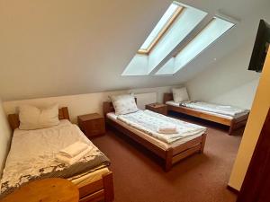 a attic room with two beds and a skylight at Noclegi Kołek in Pogórze