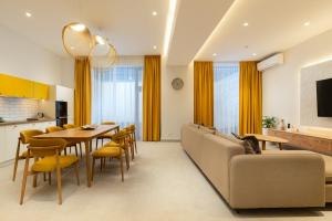 a dining room and living room with a table and a couch at IGMAR Villas & Aparts Hotel in Tashkent