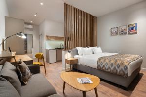 a hotel room with a bed and a couch at IGMAR Villas & Aparts Hotel in Tashkent
