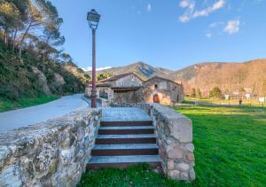 a stone wall with stairs leading to a building at Apartaments Rural Montseny in gualba de Dalt