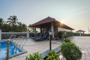 a resort with a pool and a gazebo at Casa Marina Beachfront Resort in Padubidri