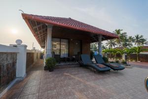 a patio with two chairs and a roof at Casa Marina Beachfront Resort in Padubidri