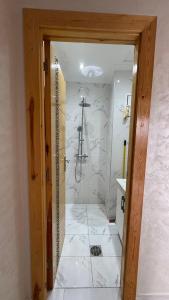 a bathroom with a shower with white marble walls at Selouane in Selouane