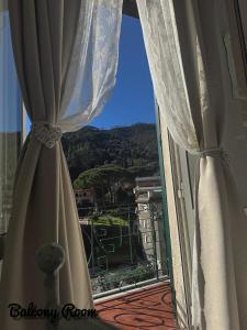 ein Fenster mit Vorhängen und Blick auf einen Berg in der Unterkunft La Muraria in Monterosso al Mare