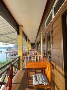 a table and bench on a balcony of a restaurant at Tena Don Det Sunset Guest House in Don Det