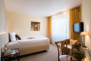 a hotel room with a bed and a tv at Hotel zur Mühle in Paderborn