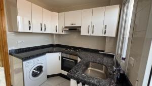 a kitchen with a sink and a washing machine at Selouane in Selouane