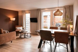 a dining room and living room with a table and chairs at Appartement Wadpier in Buren
