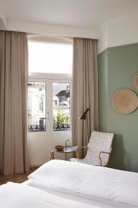 a bedroom with a bed and a chair and a window at Hotel Park Bergen, Historic Hotels of Europe in Bergen