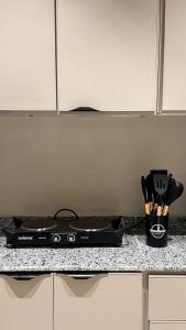 a black stove top on a counter in a kitchen at ZA apartment in Al Ahsa +17 photos