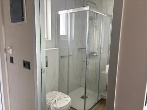 a bathroom with a glass shower with a toilet at Barbie II in Ialysos +6 photos