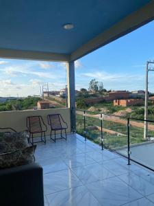 a balcony with two chairs and a view of a field at Ramos hotel in Barreirinhas +14 photos