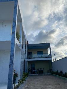 a house with a balcony and a cloudy sky at Ramos hotel in Barreirinhas