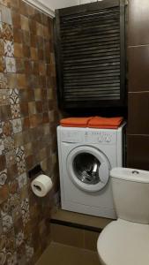 a bathroom with a washing machine and a toilet at Apartment on Sibirskaya st. 33 in Novosibirsk