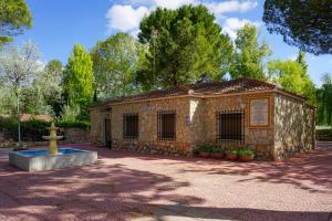an old building with a fountain in a park at Casa Rural RosaVera in Ossa de Montiel