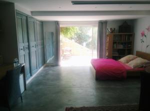 a bedroom with a bed and a large window at Studio rose in Cassis