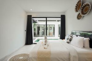 a bedroom with a bed with a cat laying on it at Dkenyeri Villa by Aayan in Tanah Lot +27 photos