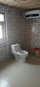 a bathroom with a toilet in a room with a window at Snow Bound Home stay in Fagu