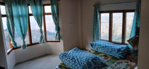 a room with two beds and two windows at Snow Bound Home stay in Fagu