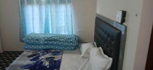 a bedroom with a bed and a blue curtain at Snow Bound Home stay in Fagu