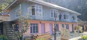 a man standing on the roof of a house at Snow Bound Home stay in Fagu