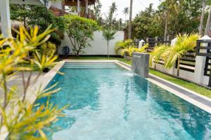 a swimming pool in the yard of a house at Villa Bee in Wennappuwa