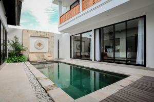a swimming pool in the middle of a house at Dkenyeri Villa by Aayan in Tanah Lot