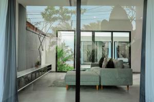 a living room with a couch and a table at Dkenyeri Villa by Aayan in Tanah Lot