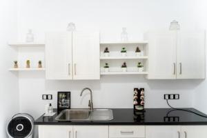 a kitchen with white cabinets and a sink at Villa Bee in Wennappuwa