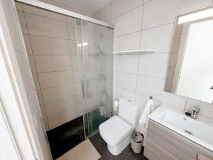 a bathroom with a toilet and a sink and a shower at apartment in La Santa, Lanzarote, village by the Sea in La Santa +13 photos