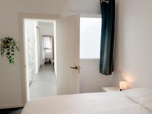 a bedroom with a white bed and a hallway at apartment in La Santa, Lanzarote, village by the Sea in La Santa