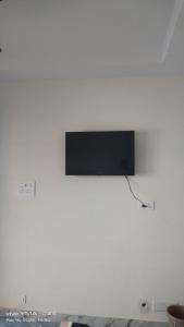 a flat screen tv hanging on a white wall at Rr suites in Kākināda