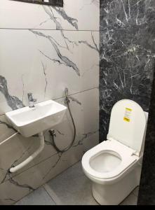 a bathroom with a toilet and a sink at Rr suites in Kākināda
