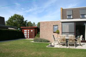 a patio with chairs and a table in front of a house at Heggerank 3A in Nieuwvliet